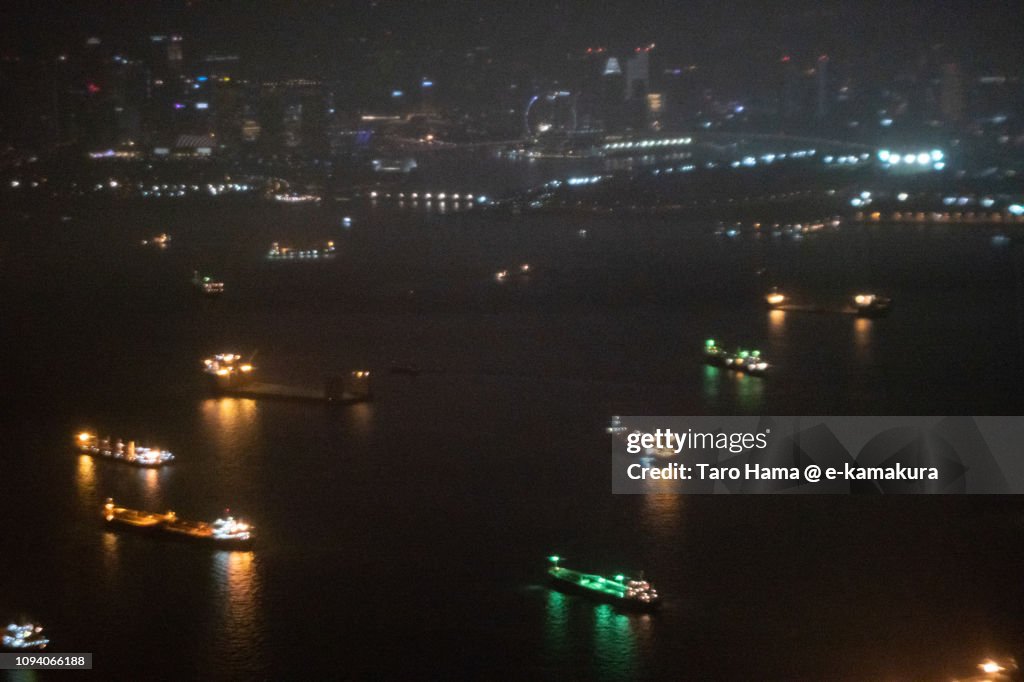 Many tankers on Singapore Strait in Singapore night time aerial view from airplane