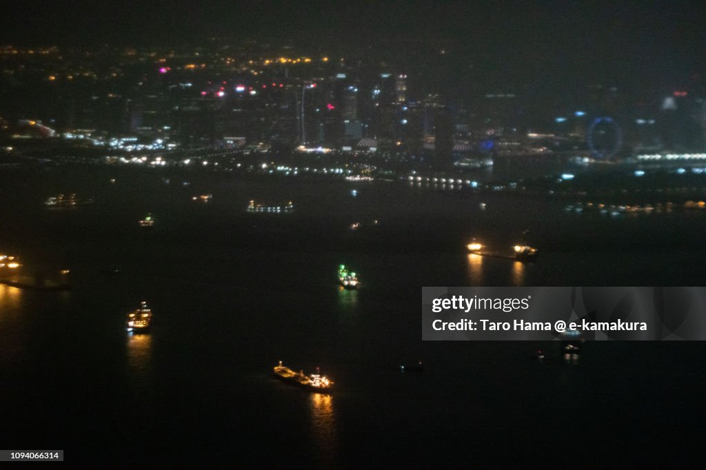 Many tankers on Singapore Strait in Singapore night time aerial view from airplane