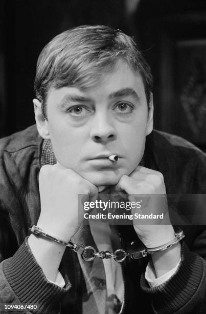 Welsh actor Hywel Bennett handcuffed while rehearsing for the play 'Night Must Fall', Shaw Theatre, London, March 19th 1975.