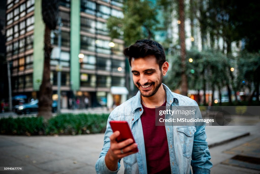 Handsome Indian man using mobile phone.