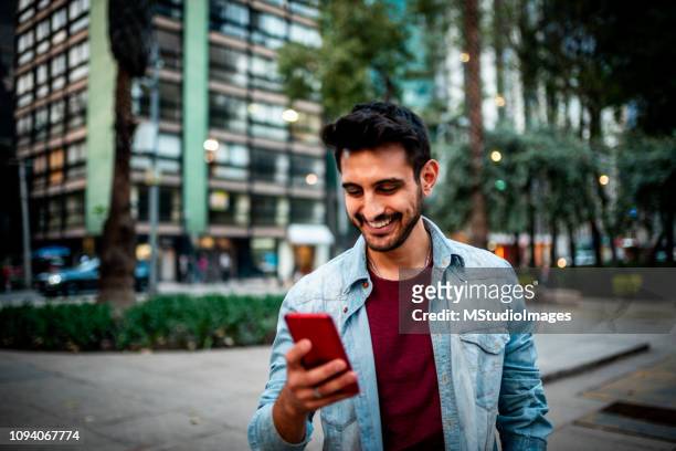 handsome indian man using mobile phone. - portable information device stock pictures, royalty-free photos & images