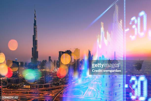 stock market exchange on a skyscraper in dubai background - gulf countries stock-fotos und bilder