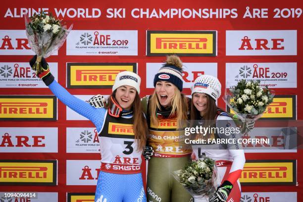 Silver medallist Italys Sofia Goggia, gold medallist US Mikaela Shiffrin and bronze medallist Switzerland's Corinne Suter celebrate during the flower...