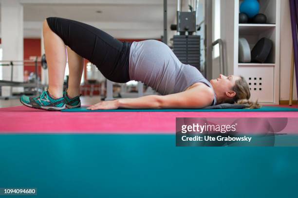 Bonn, Germany Young pregnant woman training in a gym, on January 24, 2019 in Bonn, Germany. The woman is eight months pregnant and is doing...