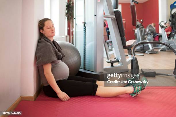 Bonn, Germany Young pregnant woman after the training in a gym, on January 24, 2019 in Bonn, Germany. The woman is eight months pregnant is relaxing.