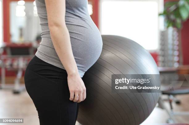 Bonn, Germany Young pregnant woman training in a gym, on January 24, 2019 in Bonn, Germany. The woman is eight months pregnant and is doing...