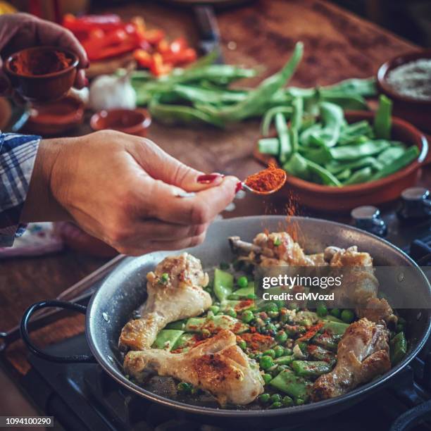 zubereitung von paella huhn mit grünen bohnen, erbsen und paprika - paella stock-fotos und bilder