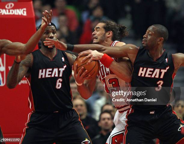 Joakim Noah of the Chicago Bulls battles for control of the ball with LeBron James and Dwyane Wade of the Miami Heat at the United Center on February...
