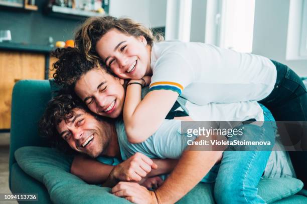 glücklicher vater mit teenagern - group on couch stock-fotos und bilder