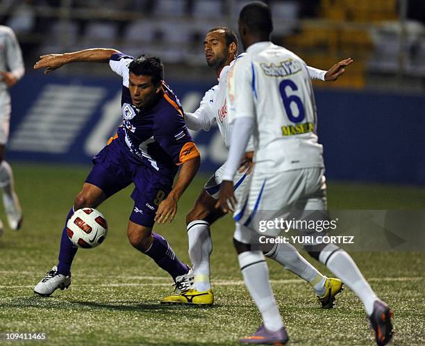 Alejandro Sequeira of the Costa Rican team Deportivo Saprissa fights for the ball with Fabio de Souza and Juan Carlos Garcia of the Honduran team...