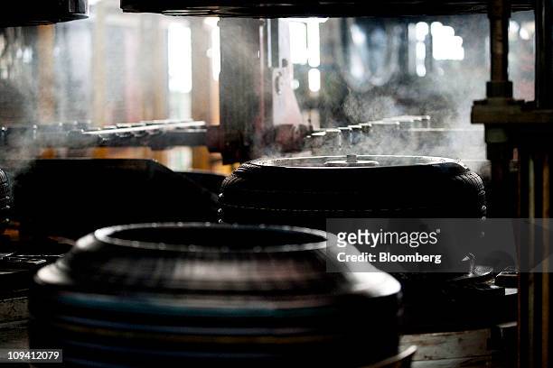 Steam rises from tires as they come out of a mold at the Pirelli & C SpA tire factory in Jining, Shandong Province, China on Thursday, Feb. 24, 2011....