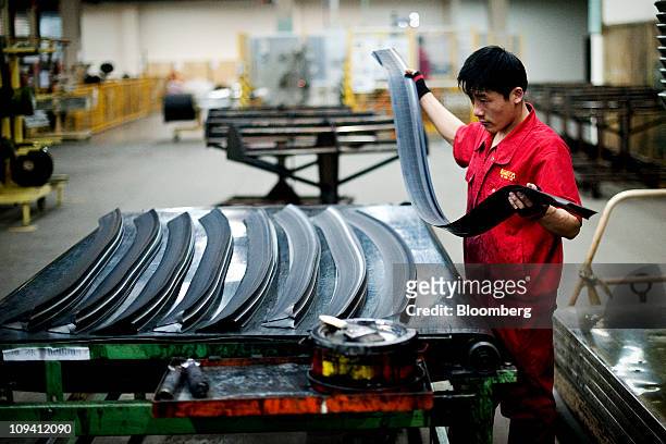 Factory worker lays out strips of rubber to produce tires at the Pirelli & C SpA tire factory in Jining, Shandong Province, China on Thursday, Feb....
