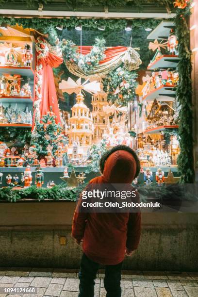 little boy looking at store window on christmas - christmas toys stock pictures, royalty-free photos & images