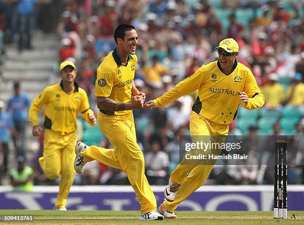 Mitchell Johnson of Australia celebrates with team mate David Hussey after taking the wicket of James Franklin of New Zealand during the 2011 ICC...