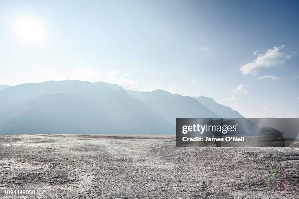 flat rocky plateau with distant mountains and sunlight - plateau landelement stockfoto's en -beelden