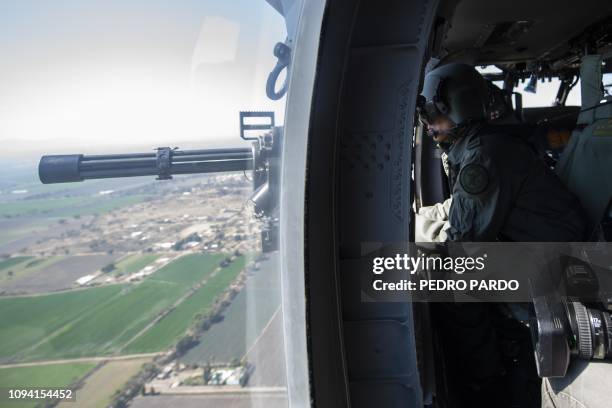 Soldiers on an Air Force Blackhawk helicopter fly over the Mexican state of Guanajuato on February 4, 2019 during an operation to fight illegal taps...