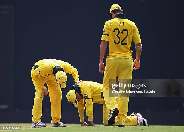 Michael Clarke and Shaun Tait of Australia check to see if Ricky Ponting is alright, after hurting his hand during the 2011 ICC World Cup Group A...