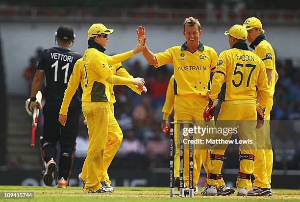 Brett Lee of Australia is congratulated by Steven Smith, after claiming the wicket of Daniel Vettori, after he was caught by Brad Haddin during the...