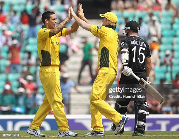 Mitchell Johnson of Australia celebrates with team mate Cameron White after taking the wicket of Nathan McCullum of New Zealand during the 2011 ICC...