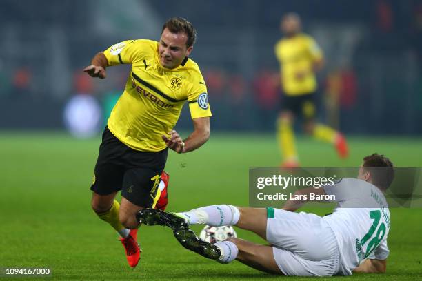 Niklas Moisander of Werder Bremen tackles Mario Gotze of Borussia Dortmund during the DFB Cup match between Borussia Dortmund and Werder Bremen at...