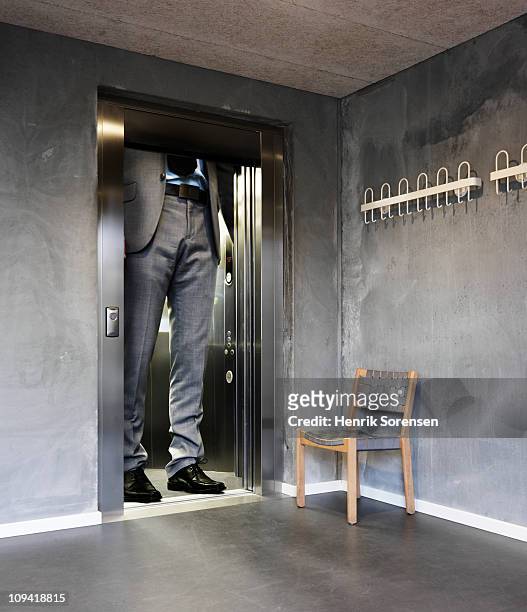oversized businessman in an elevator - little big man photos et images de collection