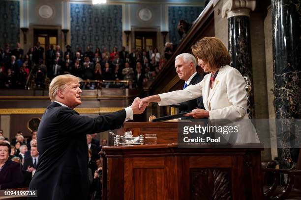 President Donald Trump shakes hands with Speaker of the House Nancy Pelosi while joined by Vice President Mike Pence before delivering the State of...