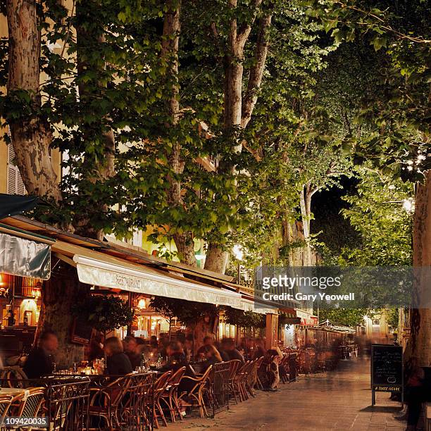 busy street lined with cafes at night - aix en provence fotografías e imágenes de stock