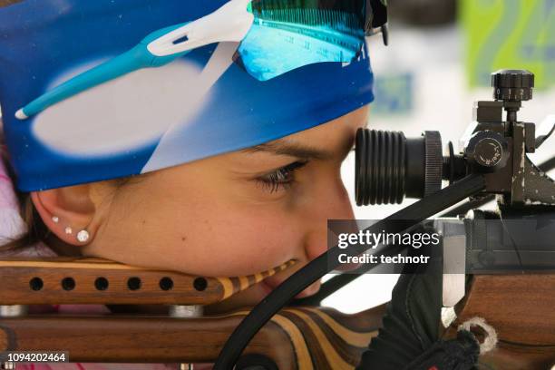 close-up shot van jonge vrouwelijke biatlon concurrent beoefenen target schieten - shooter stockfoto's en -beelden