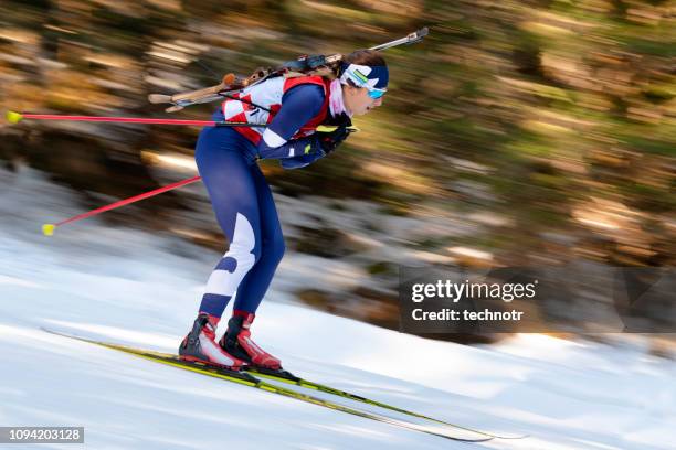 side view of female biathlon competitor at cross-country skiing, motion blurred - biathlon ski stock pictures, royalty-free photos & images