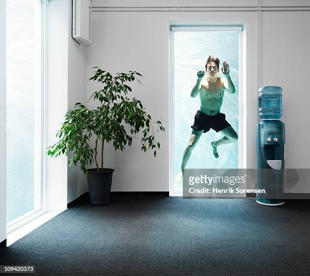 adult male swimmer outside an office window - ahogarse fotografías e imágenes de stock