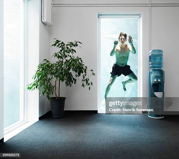 adult male swimmer outside an office window - drowning foto e immagini stock