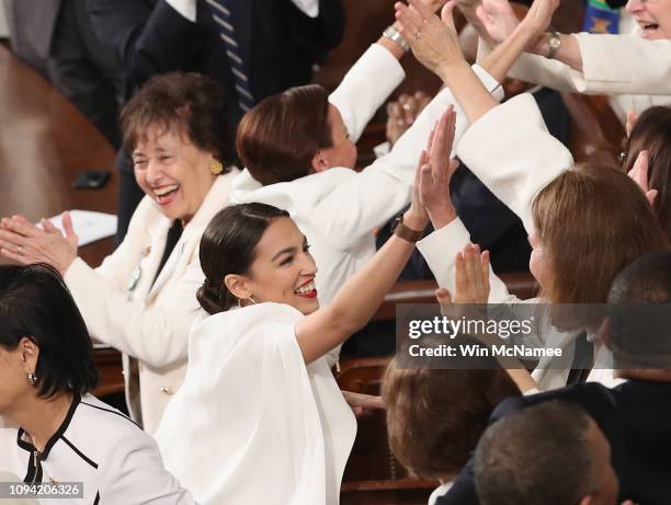 Rep. Alexandria Ocasio-Cortez and other female lawmakers cheer during President Donald Trump's State of the Union address in the chamber of the U.S....