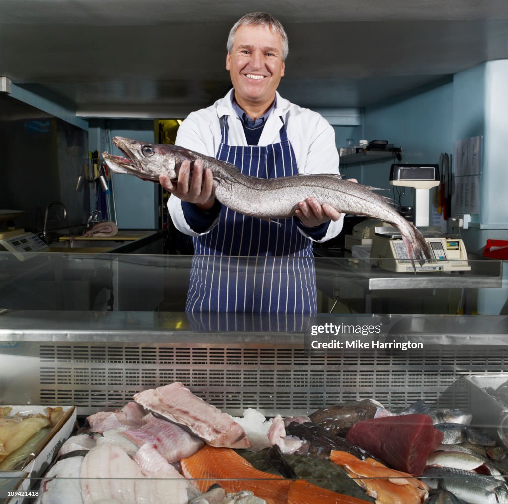 Male Fishmonger Holding Large Fish