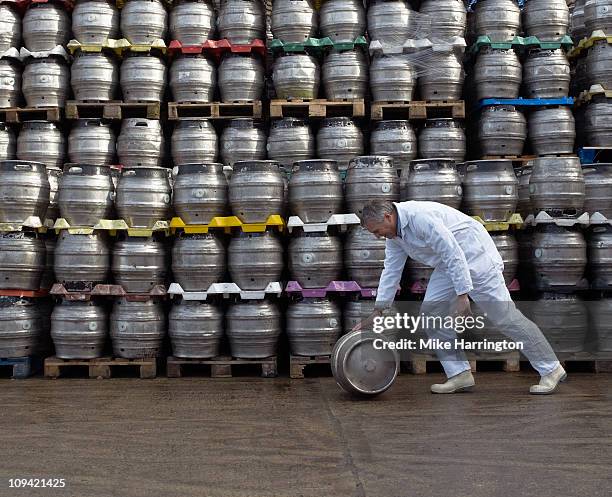 male brewer pushing keg - brouwerij stockfoto's en -beelden