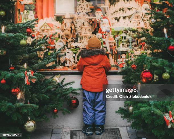 bambino in piedi vicino all'albero di natale a rothenburg - christmas decorations in store foto e immagini stock