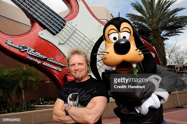 In this handout photo provided by Disney, Aerosmith drummer Joey Kramer poses with Disney character Goofy at Disney's Hollywood Studios in front of...
