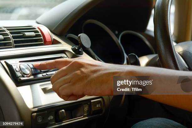 man hand on turn on radio in the car - compact disc stock pictures, royalty-free photos & images
