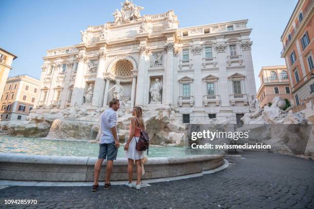 paar overweegt de trevi-fontein in rome, italië - fontein stockfoto's en -beelden