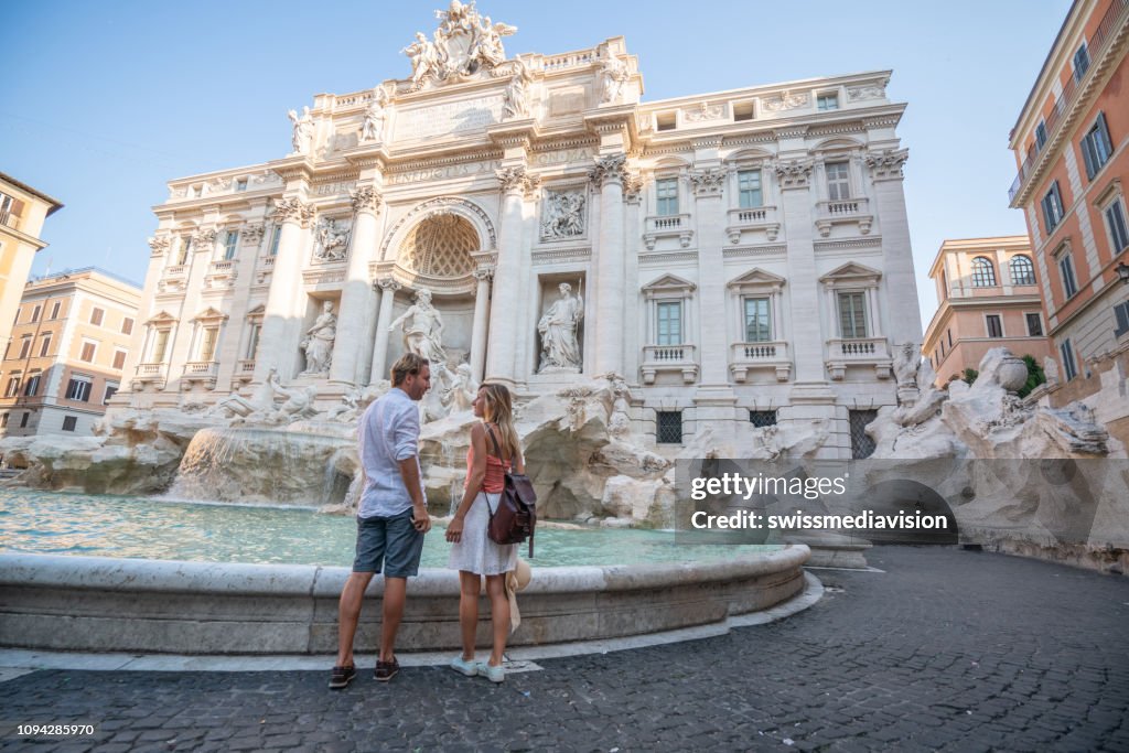 Couple contemplating the Trevi fountain in Rome, Italy