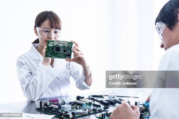female researcher who confirms the electronic board. - electronic imagens e fotografias de stock