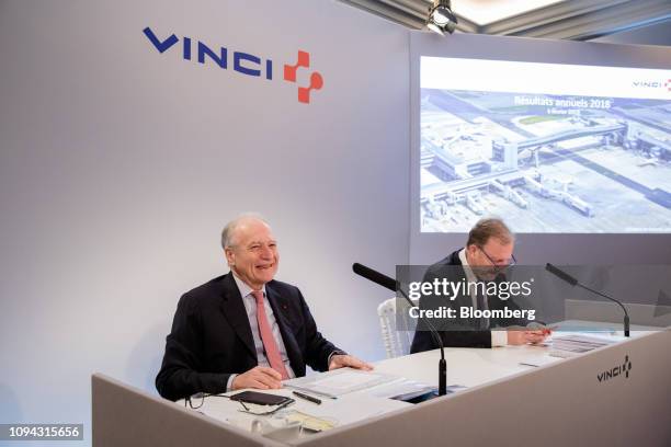 Xavier Huillard, chief executive officer of Vinci SA, left, reacts beside Christian Labeyrie, chief financial officer of Vinci SA, during the...