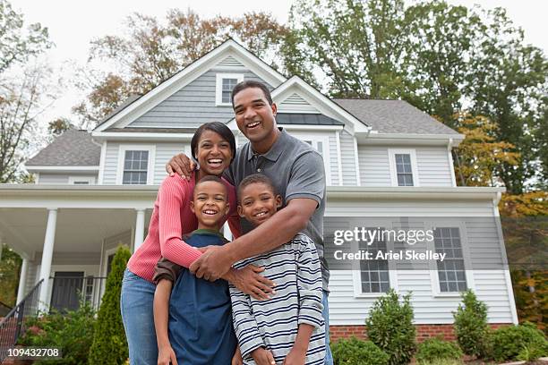 black familie stehen zusammen in front of house - family of four in front of house stock-fotos und bilder