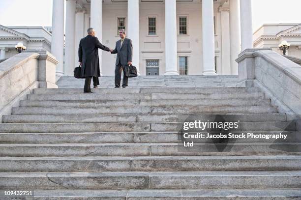 geschäftsmann beim händeschütteln auf der treppe - us capitol building stock-fotos und bilder