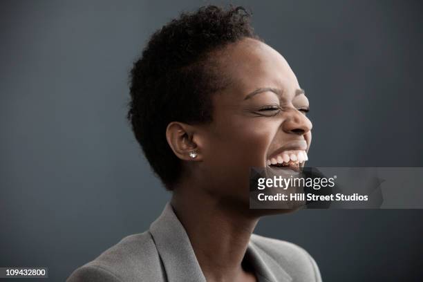 laughing african american businesswoman - one kid one world a night of 18 laughs stockfoto's en -beelden