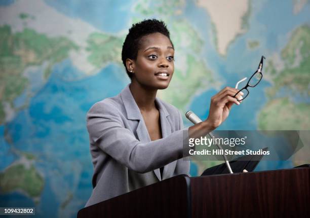 african american businesswoman talking at podium - lectern stock pictures, royalty-free photos & images