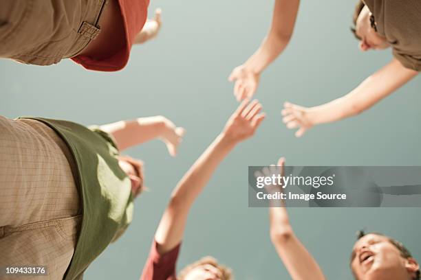 boys doing high five, low angle view - hi five stockfoto's en -beelden