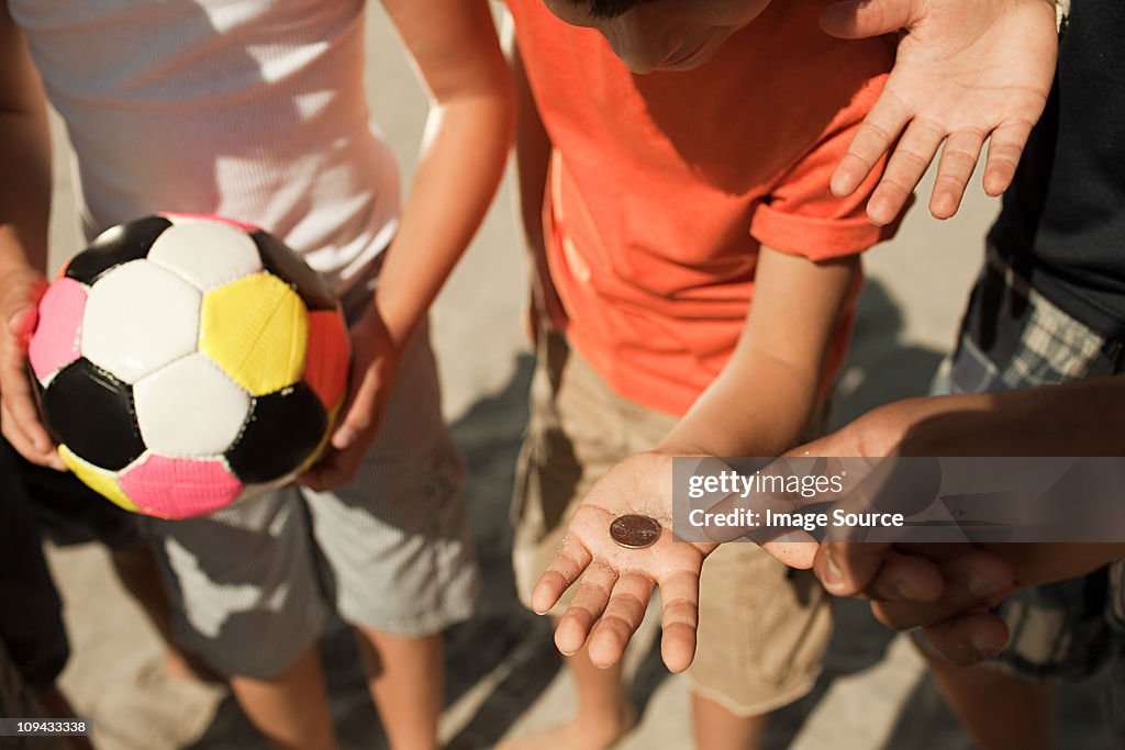 Garotos jogando uma moeda