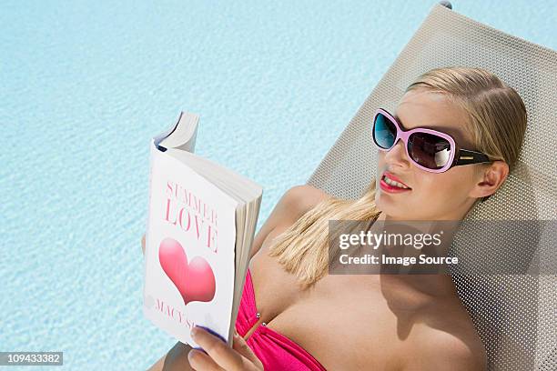 woman reading book on sunlounger on vacation - romance book stock pictures, royalty-free photos & images