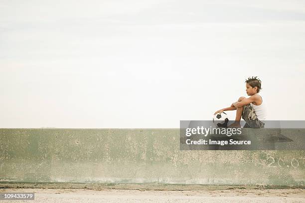 boy sitting on wall with football - boy sitting stock pictures, royalty-free photos & images