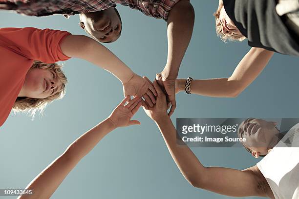 boys doing huddle, low angle view - four people stock pictures, royalty-free photos & images
